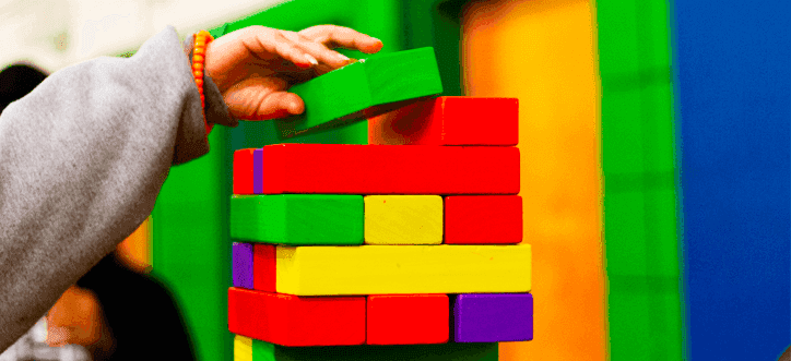 Mão de criança montando torre de brinquedo